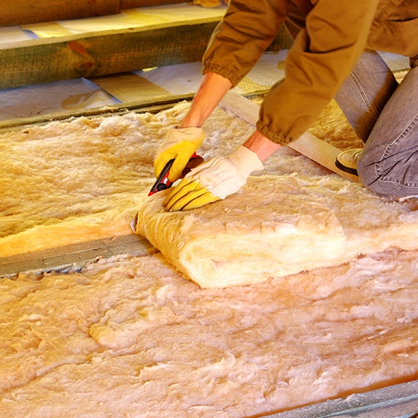 BCM Crew cutting and installing attic insulation.