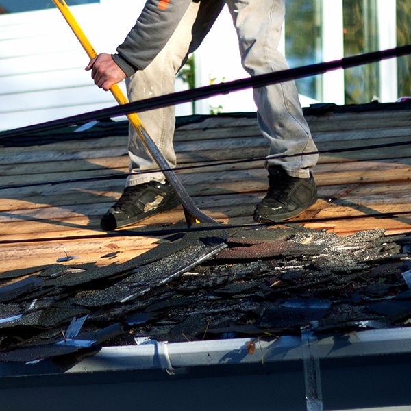 BCM Roofer removing old shingles from roof deck in Birmingham Michigan