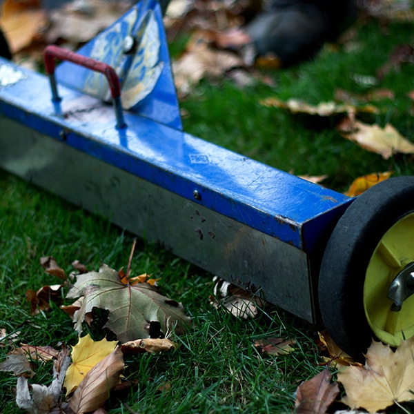 Roof debris cleanup with a magnet on a home lawn.