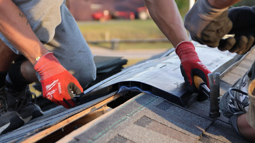 BCM Roofing crew member installing ridge vent on a house roof