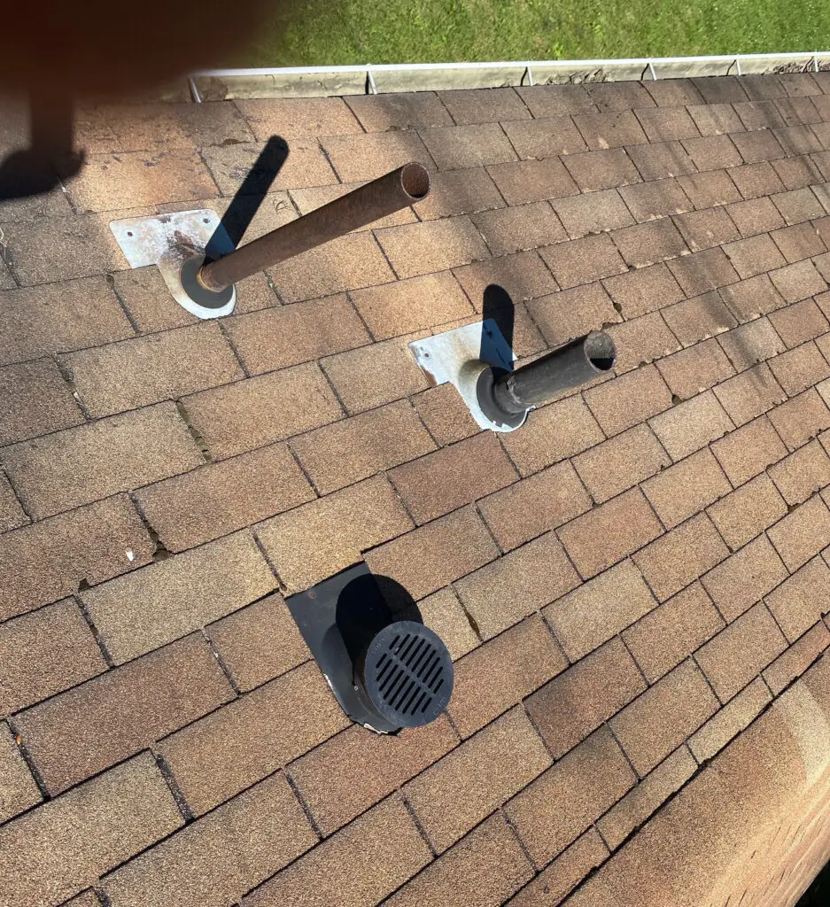 Roof Repair & Installation in Waterford Township with new Skylight 7 roof vent pipes and exhaust vents on asphalt shingle roof of residential home in waterford township mi