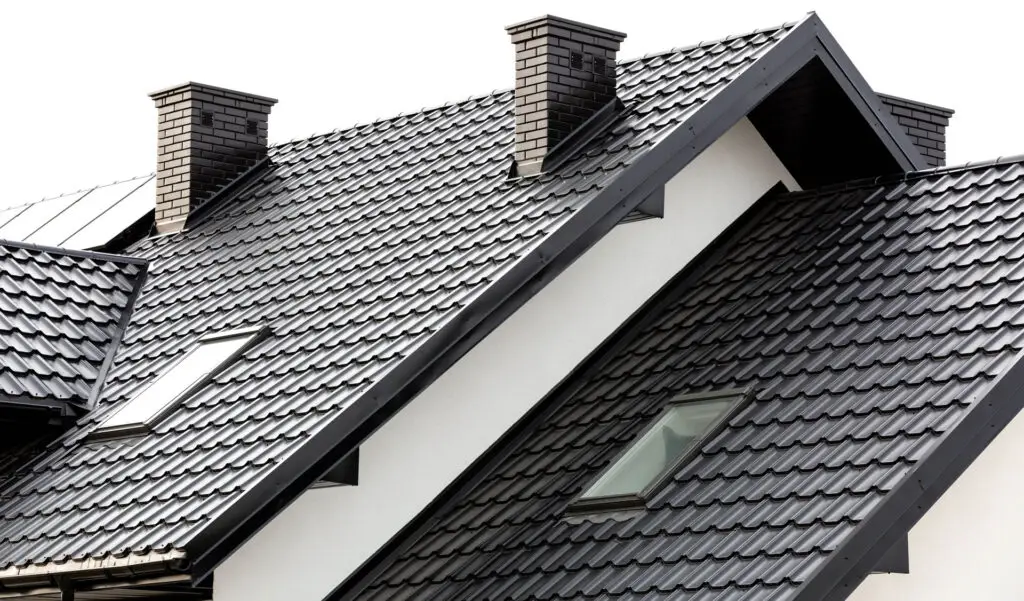 Close-up of a new home with metal roof tiles, gutters, and ceramic chimney.