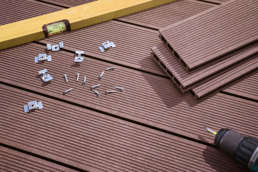 Deck installation materials including composite boards, screws, and mounting clips.