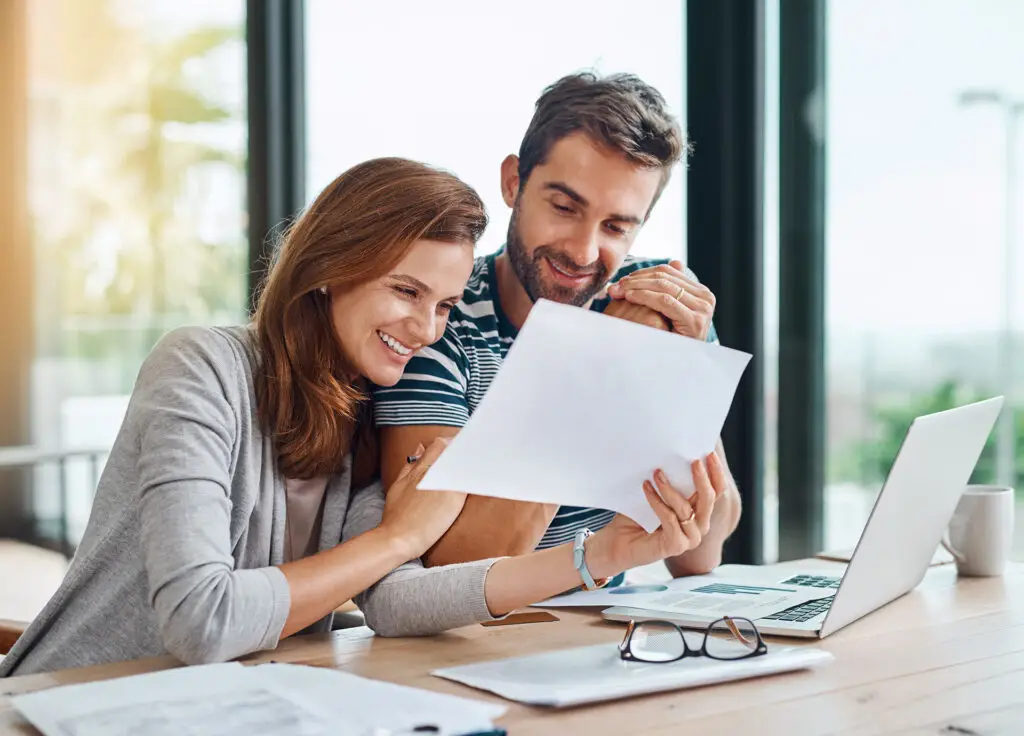 Happy homeowners reviewing roof financing options and payment plans.