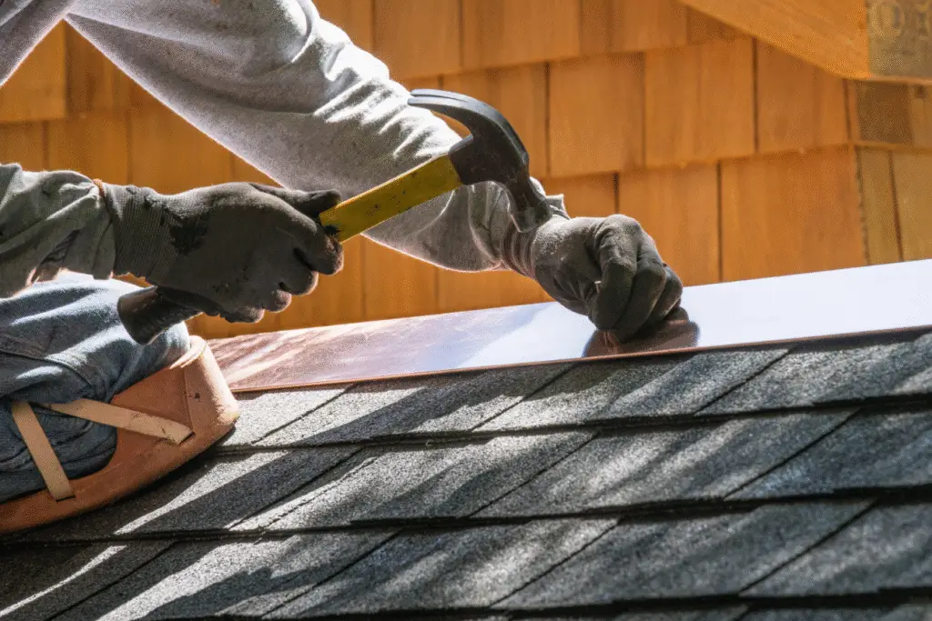 What is flashing on a roof: A contractor installing metal flashing to protect against water leaks around a chimney.