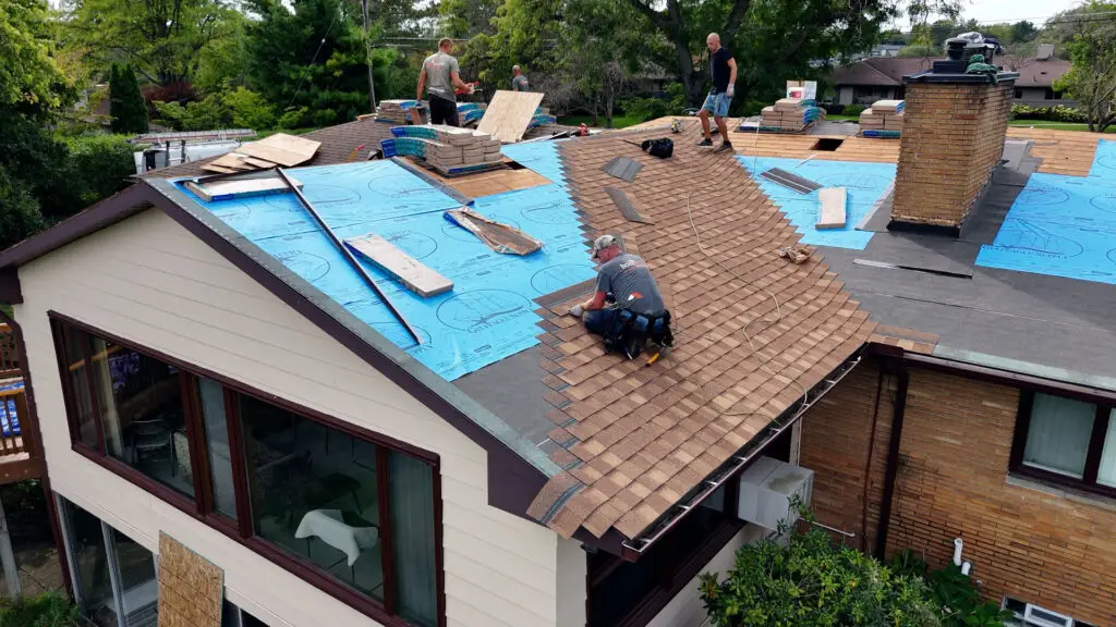 Roofing crew installing underlayment and asphalt shingles during a roof replacement in Clawson, MI.