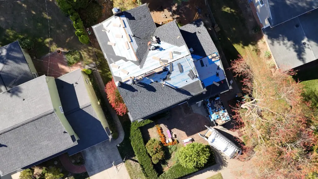 Roofing team replacing an asphalt shingle roof on a two story house in Farmington Hills, MI.